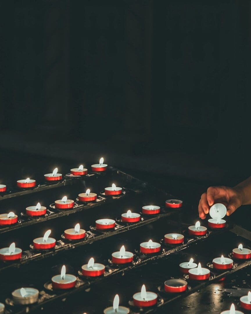 A person lighting candles on top of a table.