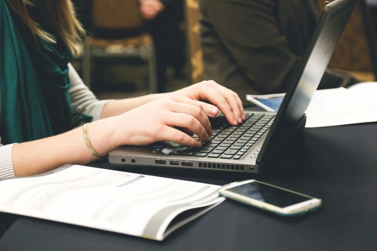 A person typing on a laptop computer.