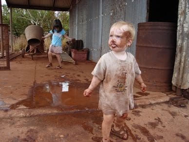 A little boy that is standing in the dirt.
