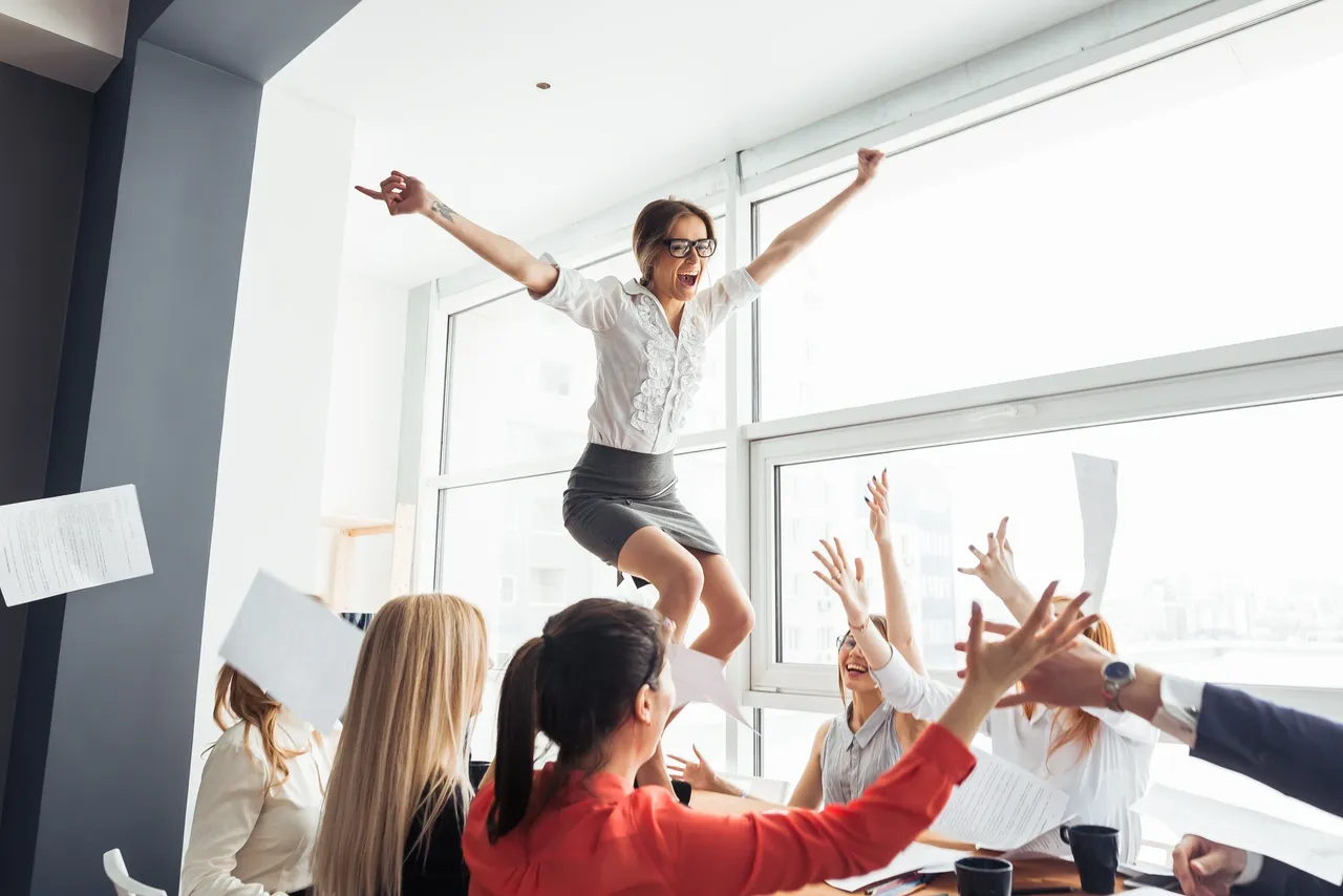 A woman jumping in the air with her arms outstretched.