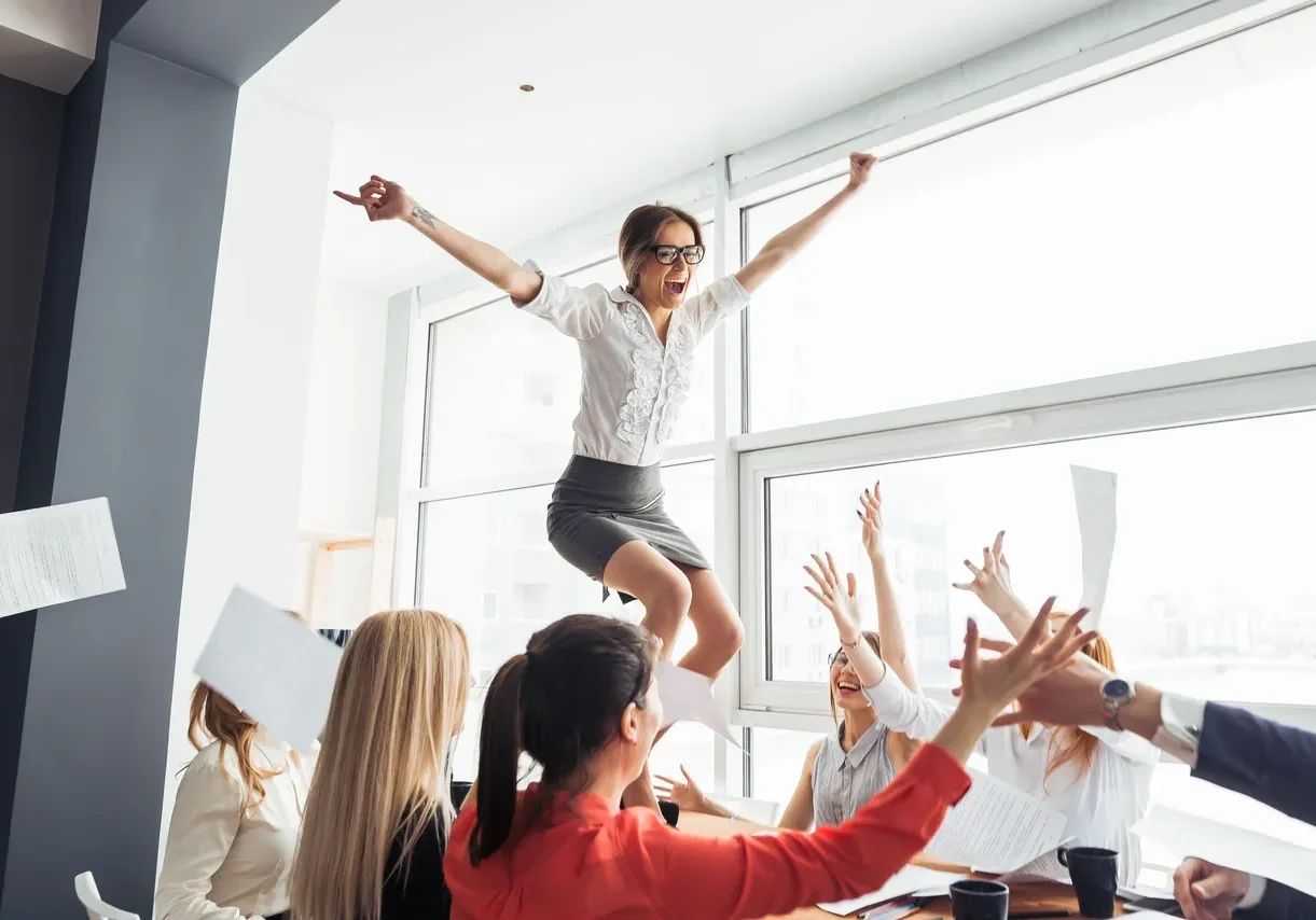 A woman jumping in the air with her arms outstretched.