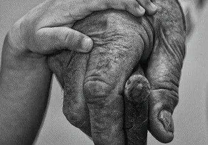 Child's hand on elderly man's hand.